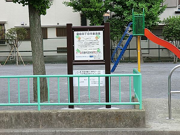 台形の敷地に滑り台などの遊具やベンチと水飲み場があります。