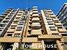 外観：爽やかな青空の下に贅沢なほどに降り注ぐ陽光、豊かな居住性。クオリティが見事に調和した住空間。（空の加工を生成AIで行っています。）