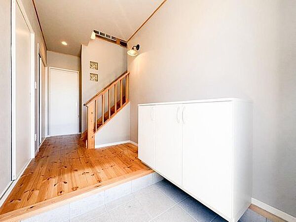 【リフォーム完成】クロス張替え、ハウスクリーニングで綺麗になりました。階段部分の吹き抜け感が玄関を広く見せ、圧迫感のない開放的な印象を与えます。大容量シューズボックス付きで収納力も確保。