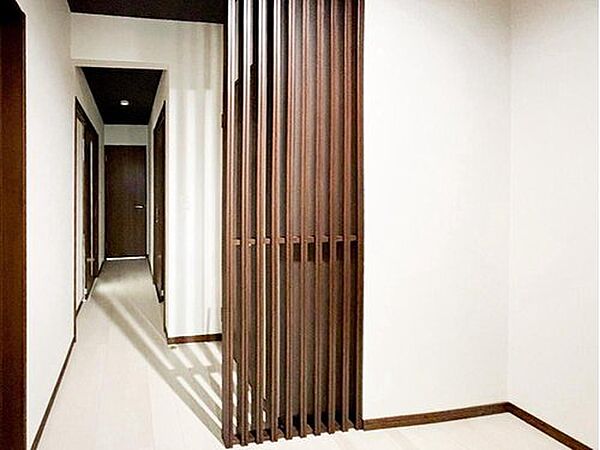 【ハウスクリーニングして綺麗にします】木目調の縦格子がアクセントの廊下。光を通しながら空間をゆるやかに仕切り、白い床との組み合わせが明るく上品な雰囲気を演出します。