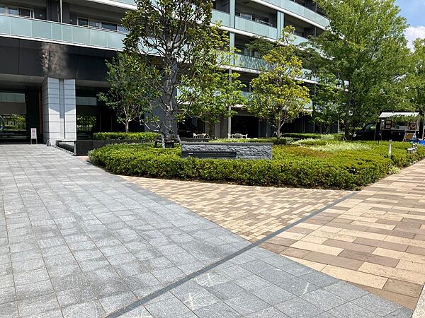 緑豊かなマンション外観とエントランス前