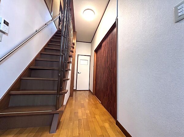 木の温もりを感じる階段まわり。手すりが備わり、収納扉やトイレへの動線もコンパクトにまとまっています。