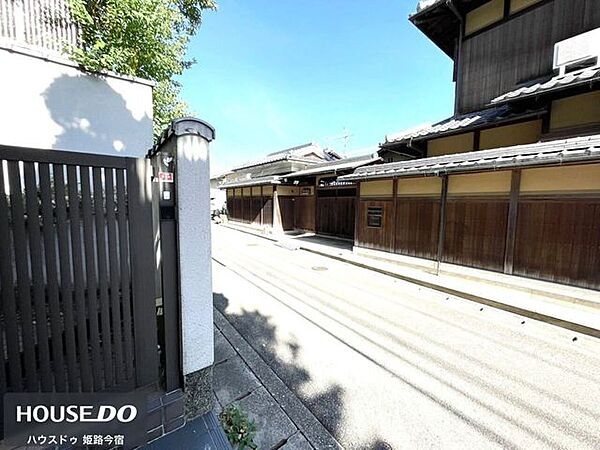 前面道路から見た現地です。門扉と塀に囲まれた和風の外観が道路沿いに続いています。
