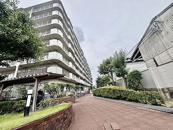 緑に囲まれたマンション外観とアプローチです。