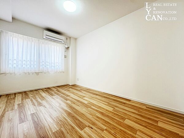 【寝室】約8帖の広々とした寝室は、主寝室にふさわしいゆとりある空間。エアコン備え付けで、入居したその日から快適に過ごせます。柔らかな木目調の床と白壁が、家族の安らぎの時間を優しく包み込みます。