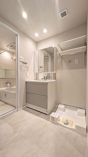 新規交換の洗面化粧台に収納棚付き！洗濯機置場も確保した機能的な空間。