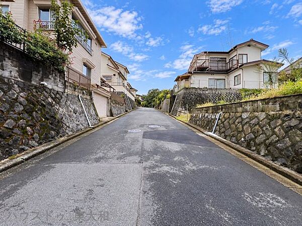 前面道路から敷地全体を見渡せる、開放感のある約60.35坪の土地。道路との高低差があり、敷地の広がりを感じられる一枚です。