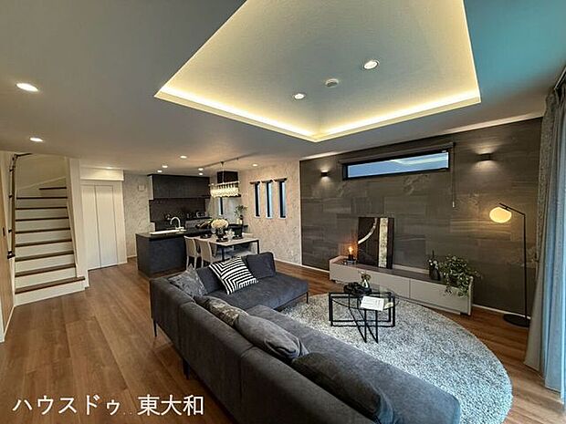 折り上げ天井が印象的な、開放感のあるリビング。間接照明が空間をやわらかく照らし、木目調の建具と調和した落ち着きのある住空間です。
