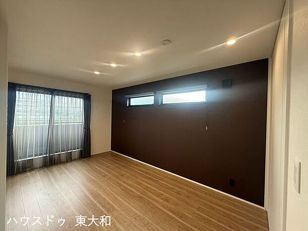 落ち着いたアクセントクロスが印象的な居室。明るい陽射しが差し込み、家具を置いた暮らしもイメージしやすい空間です。