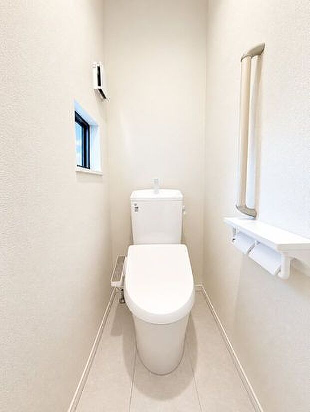 温水洗浄便座を備えた清潔感のあるトイレ。手すり付きで使いやすさにも配慮されています。