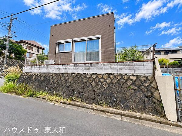 道路側から建物をしっかりと確認できる外観。高低差を活かした敷地に建ち、フェンスで囲まれたスペースはプライベート感も感じられます。落ち着いた外観デザインも魅力です。