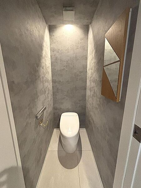 グレーのクロスやペーパーホルダーにもこだわったトイレ空間です。タンクレスでお掃除も楽々です。