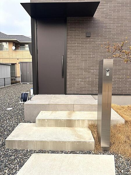 2023年築。？上質なブラウンのドアにポスト一体型のインターフォンがマッチしたこだわりの玄関周りです