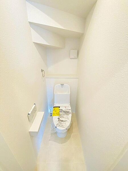 階段下スペースをうまく利用した洋式トイレ。壁付リモコン仕様の温水洗浄便座機能付きです。