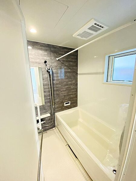 グレーのパネルで落ち着いた雰囲気のバスルーム。しっかりと足を伸ばして入浴できリラックスできます。