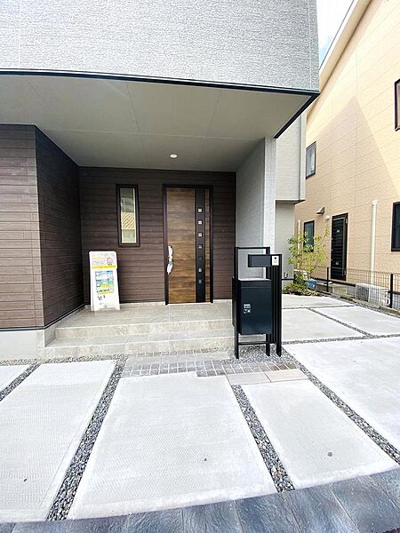 雨の日でも濡れずに鍵を開けたり、ベビーカーを一時的に置いたりできる実用的な玄関スペースです。