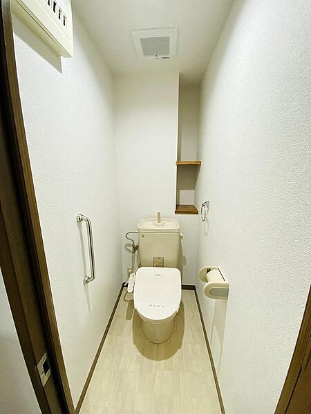 2026年3月に交換済みの温水洗浄機能付きトイレ。手すりや小物が置ける棚があるのも嬉しいポイント！