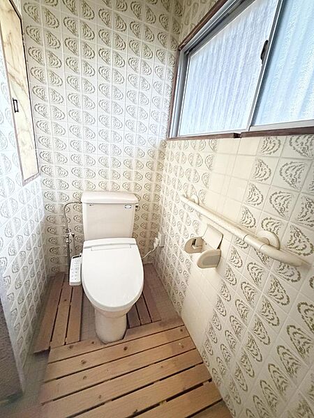 大きな窓から光が差し込む明るく清潔感のあるトイレです