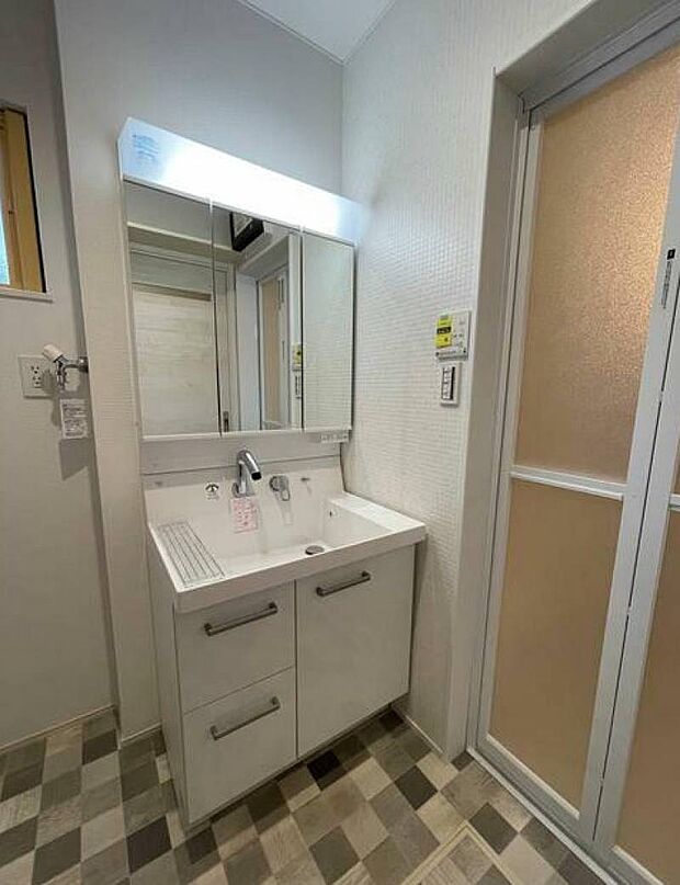 人気の三面鏡付洗面台。鏡裏は全面収納スペースになっています。深型の洗面台が小物洗いにとっても便利。もちろん、シャワーヘッドも付いてます。