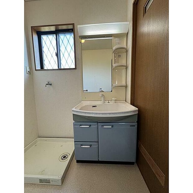 洗面室です。洗面化粧台と洗濯スペースがあります。洗濯機パンが設置されています。？？
