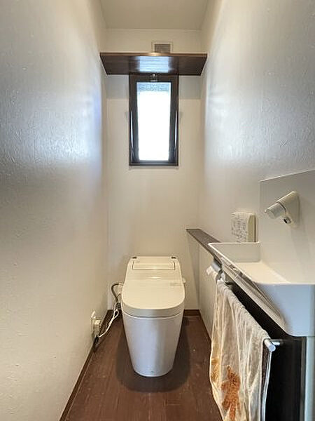 1階トイレは手洗い付きで衛生的です。背面上部にはトイレットペーパー等を収納できる棚もあります。