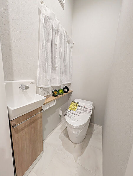 1階のトイレ　手洗い付きのタンクレストイレです