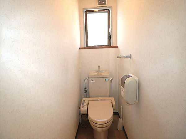 淡い色調のクロスが落ち着いた空間を演出する、小窓付きの綺麗なトイレです。