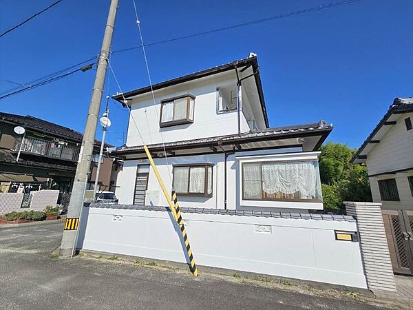 白い外壁と瓦葺きの塀が青空に美しく映える、上品な佇まいです。