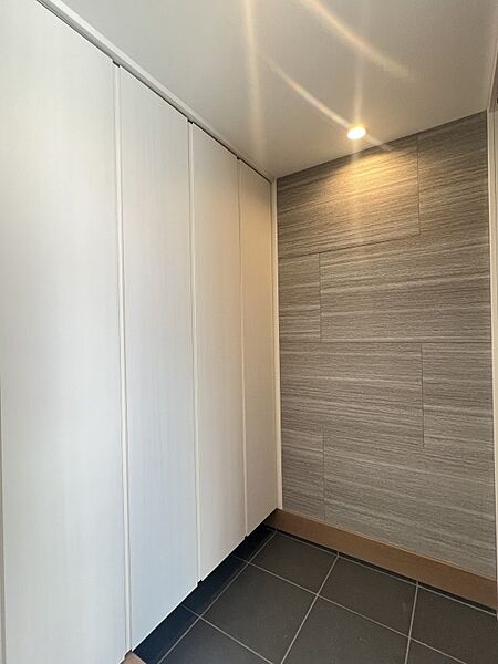 玄関収納を確保しながら、内装材でアクセントをいれております。