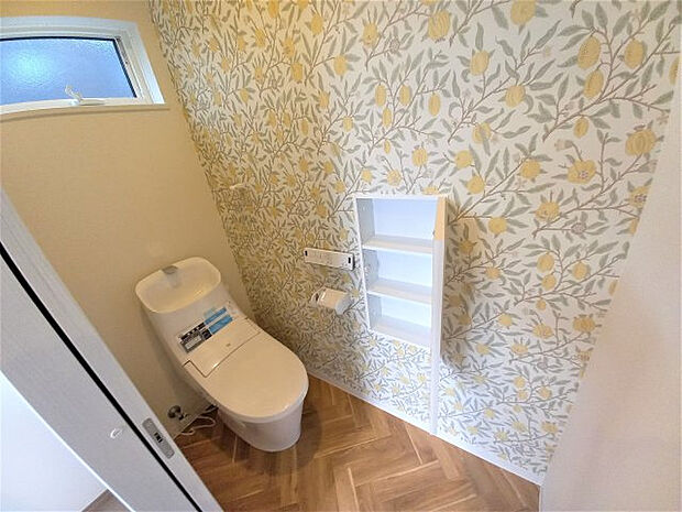 【トイレ】ヘリボーン柄のフローリングにオシャレなクロス。壁埋込収納もありトイレットペーパーの保管もしやすい！