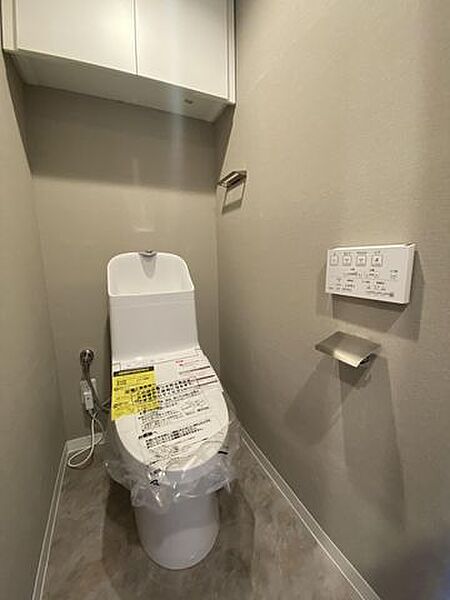【トイレ】扉付きの吊り戸棚があるため、備品を目隠しして収納できます。