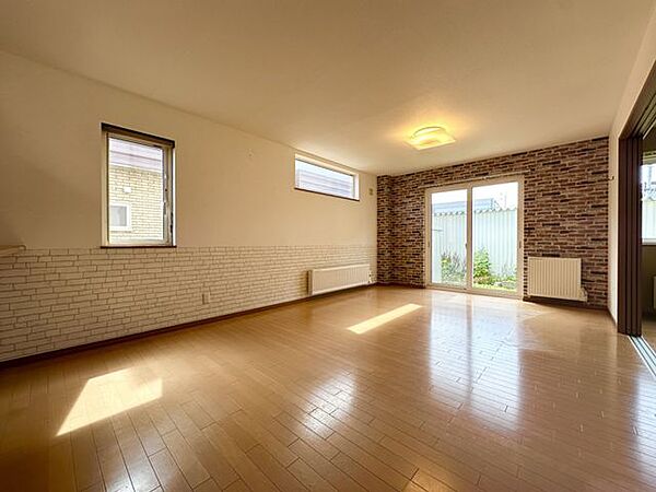 【リビング】大きな掃き出し窓から陽光が差し込み、木目の床をやさしく照らすLD。