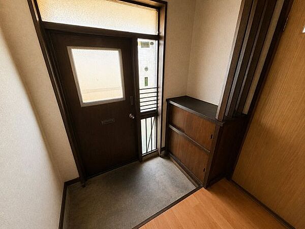 すりガラスから光が差し込む玄関。収納に便利な下駄箱付き。※現地の撮影写真を基にCG加工編集済