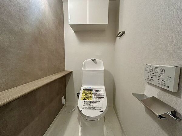 【トイレ】やわらかな色合いのアクセントクロスが、落ち着きを添えるトイレ空間。