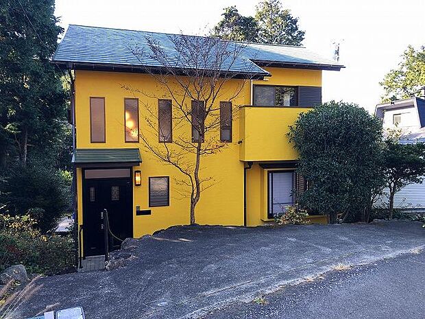 特徴ある黄色の外壁の一戸建