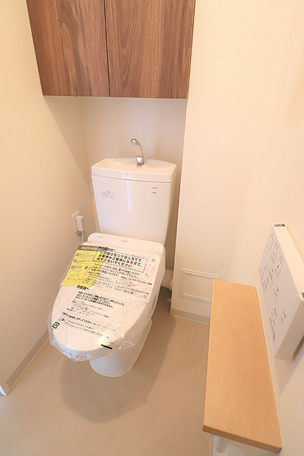 温水洗浄機能付きトイレ 上部には消耗品等を収納できる便利な戸棚がございます