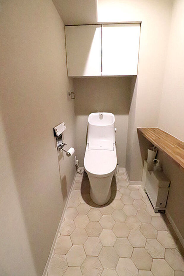 温水洗浄機能付きトイレ。上部の吊戸棚には掃除用品や消耗品等を収納できます