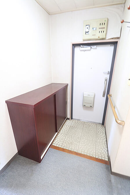収納棚と手すりを備えた、使いやすい玄関スペース