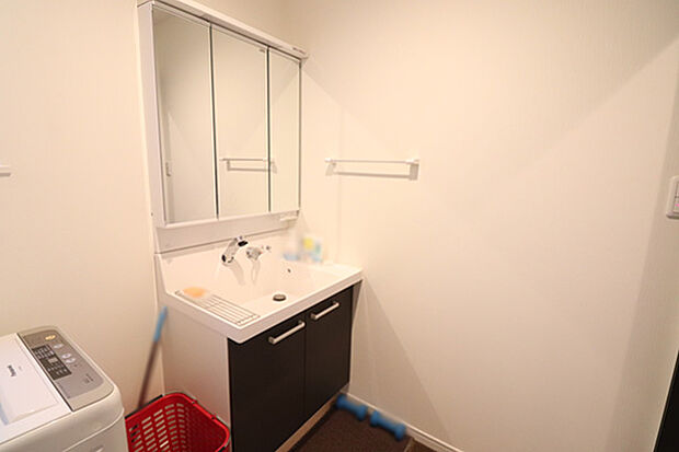 洗面所の写真です。三面鏡洗面化粧台には収納箇所もございます。