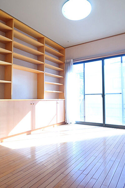 1階洋室約5.2帖のお部屋です。東側の壁面一面が棚と収納になっています。