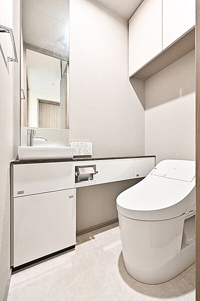 温水洗浄便座付きのトイレです。手洗いカウンターや鏡・吊り戸棚が備わった、使い勝手の良い仕様です。【トイレ】