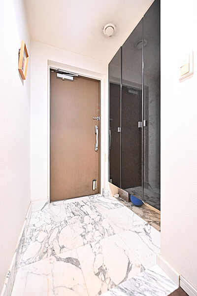 大理石調で高級感を演出した玄関に、大容量のシューズクロークが備えられています。