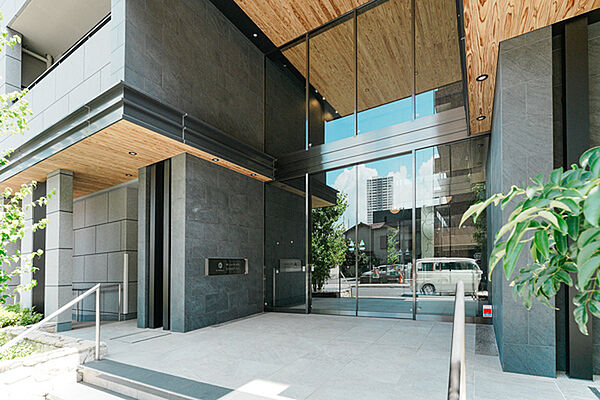 大きなガラス面と整然とした石張りの外壁が洗練された印象を与えるエントランス。
