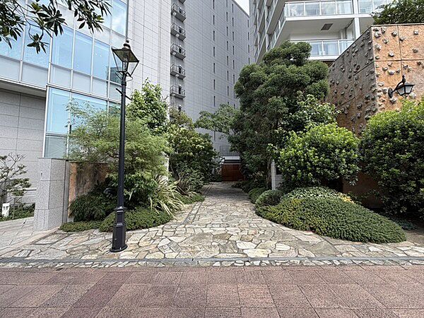 植栽が施され自然の潤いを感じられます。キッチン付きの多目的ルームやゲストルームなど多彩な共用施設有。【エントランス】