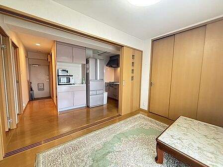 ※販売対象に家具・調度品は含まれません。洋室はキッチンと一体利用可能。キッチンは奥まった配置なのですっきりとした印象です。