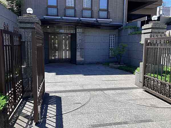 花崗岩によって重厚感のある門柱とアーティステックな門扉
