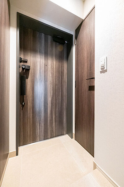 モニタ付きインターホンがあり、来訪者を確認してから対応可能。住戸玄関の外の共用廊下は内廊下設計です。【玄関】
