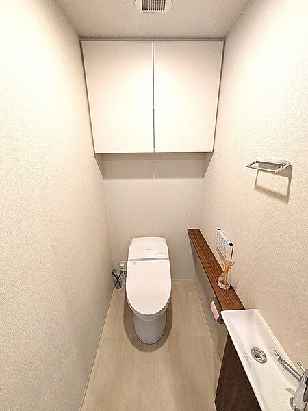 温水洗浄便座付きのトイレ。来客時にも重宝する手洗いカウンターが設けられています。