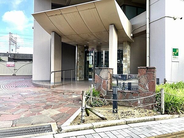 植栽に囲まれた、自然な石貼のエントランスアプローチ。ベビーカーでの移動も行いやすいスロープ付きです。【エントランス】