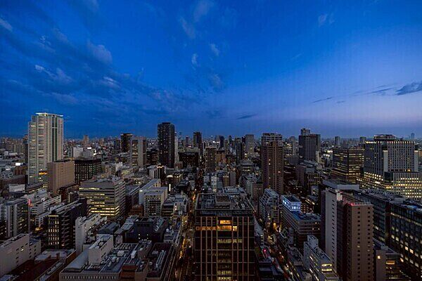 高層マンションやビルが建ち並ぶ都会的な街並み。煌びやかな大阪都心部の夜景を望めます(天候による)。【住戸からの眺望】